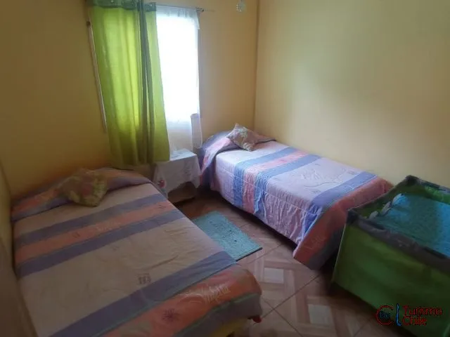 Habitación con dos camas individuales y cuna, paredes amarillas