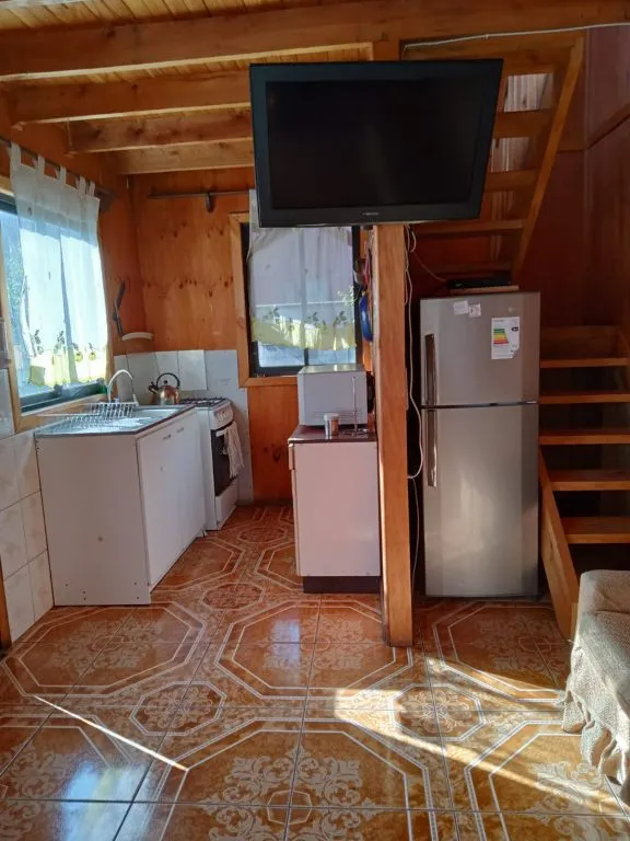 Cocina equipada de Cabañas La Ita con refrigerador, cocina a gas y TV