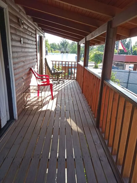 Terraza de madera en el segundo piso de Cabañas La Ita con sillas y vista al entorno