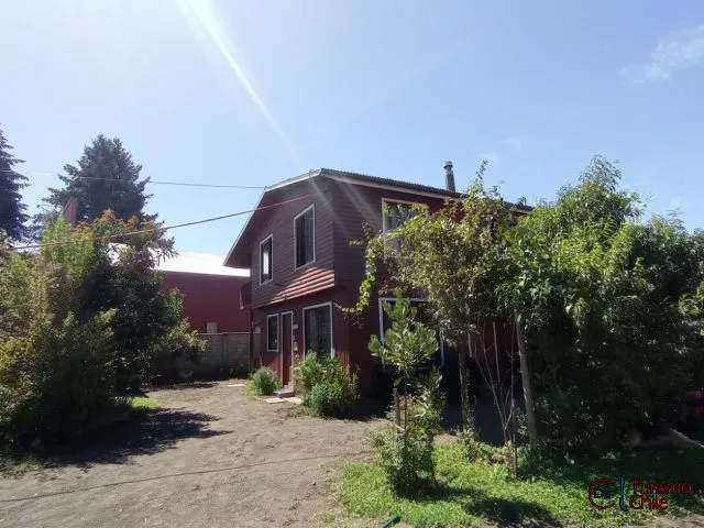 Cabaña roja de dos pisos rodeada de árboles y vegetación en Salto del Laja