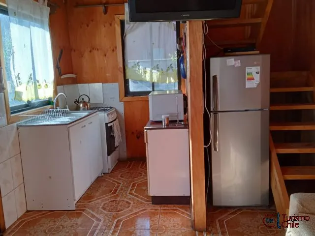 Cocina de Cabañas La Ita vista desde otro ángulo con escalera al segundo piso