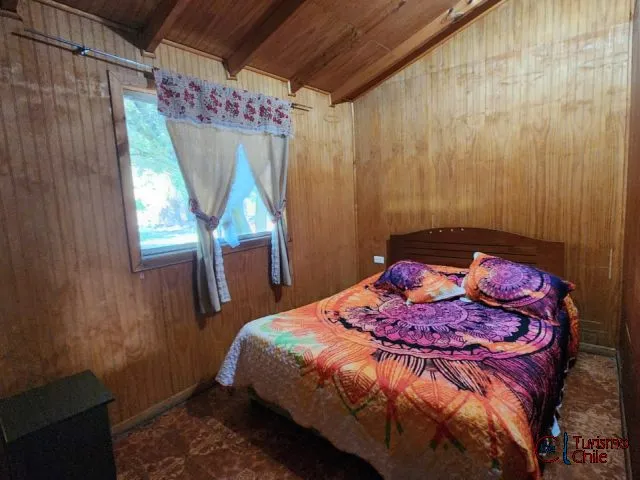 Dormitorio acogedor con cama doble y ventana con vista al jardín en Las Violetas